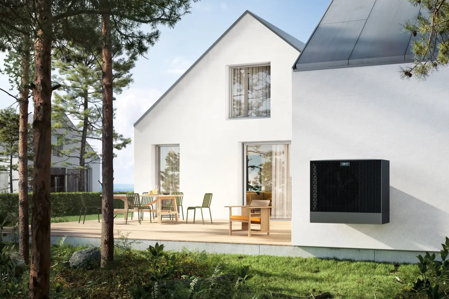Moderne Wärmepumpe an der Außenwand eines weißen Einfamilienhauses mit Holzterrasse und Gartensitzplatz in Dortmund